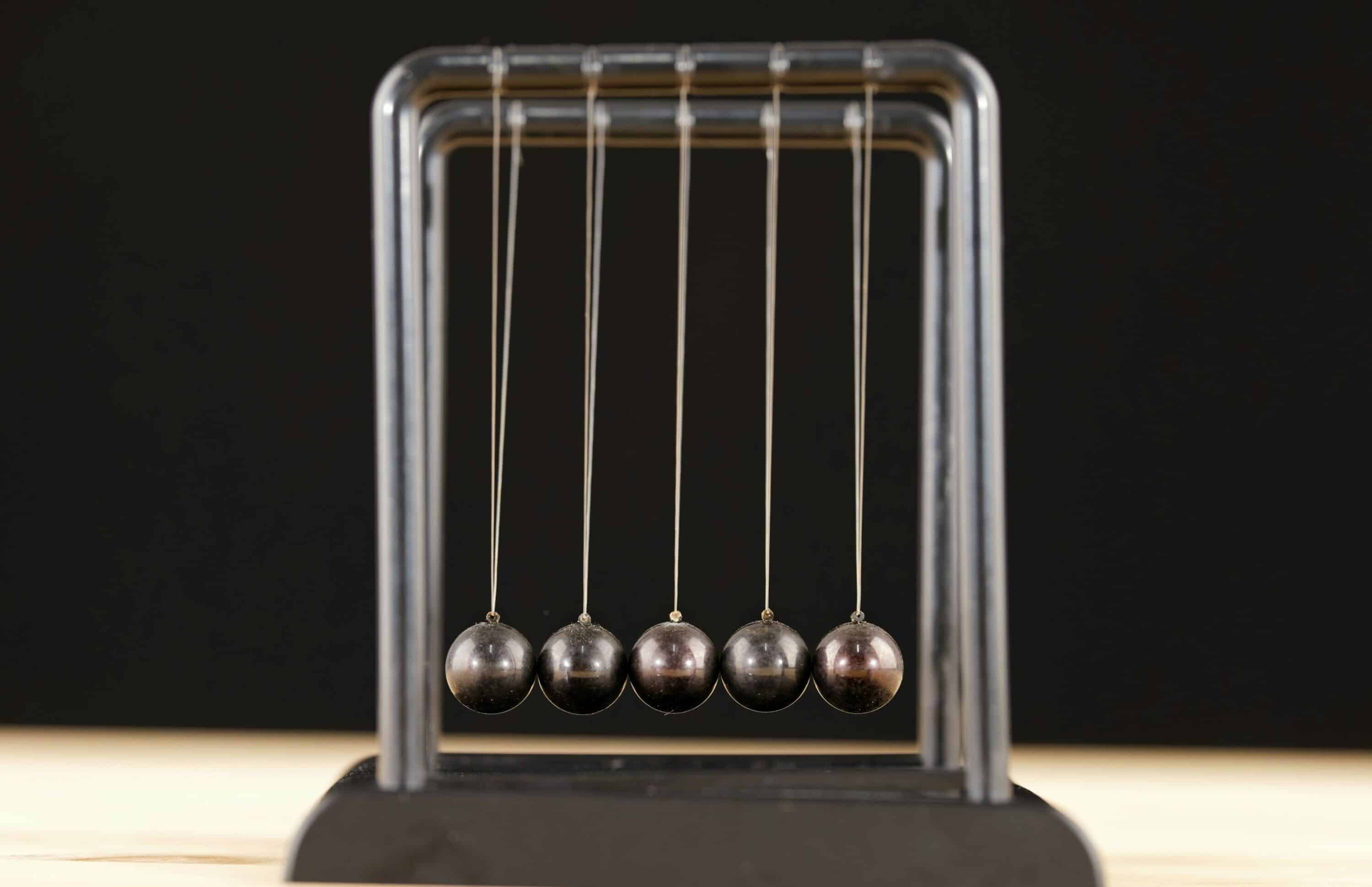 A Newton's cradle sitting on a desk