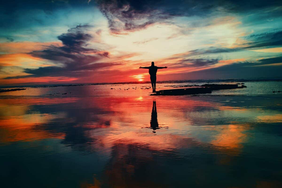 Someone standing on the beach during sunset, demonstrating the value of having a coach