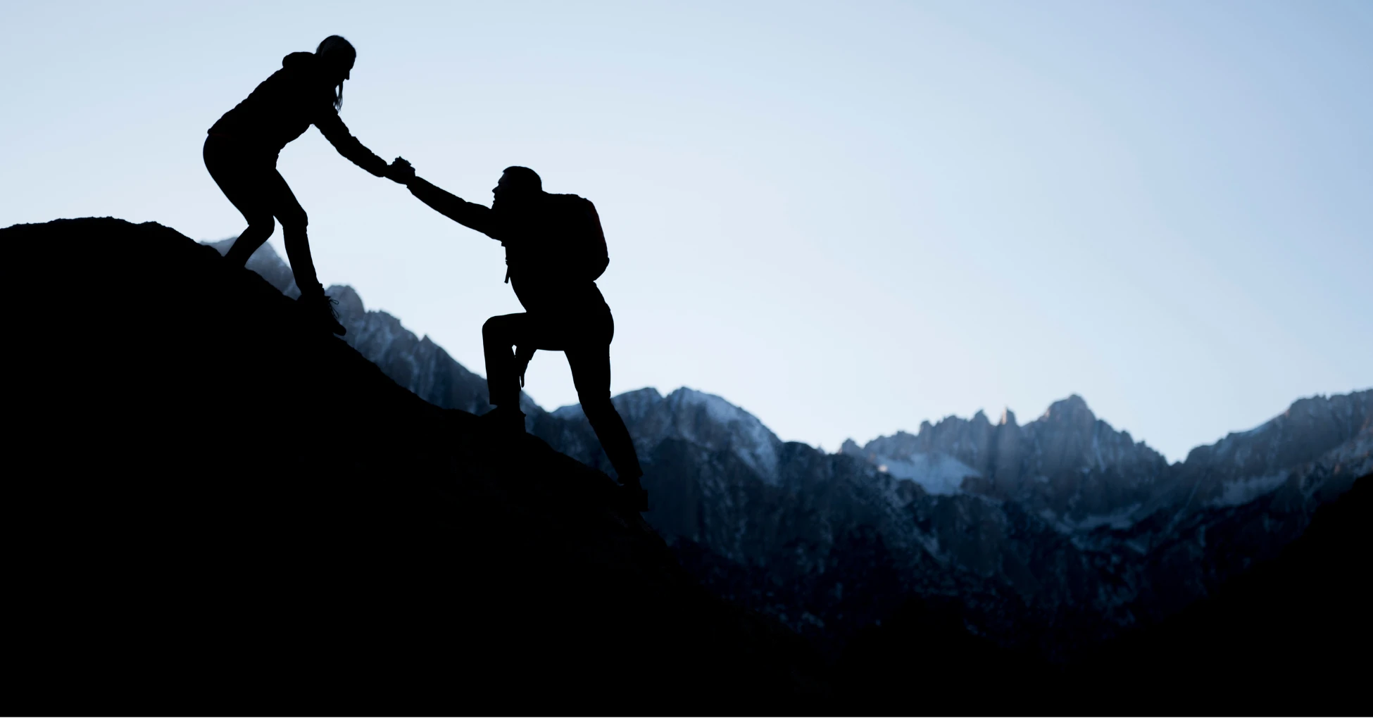people helping each other up a mountain