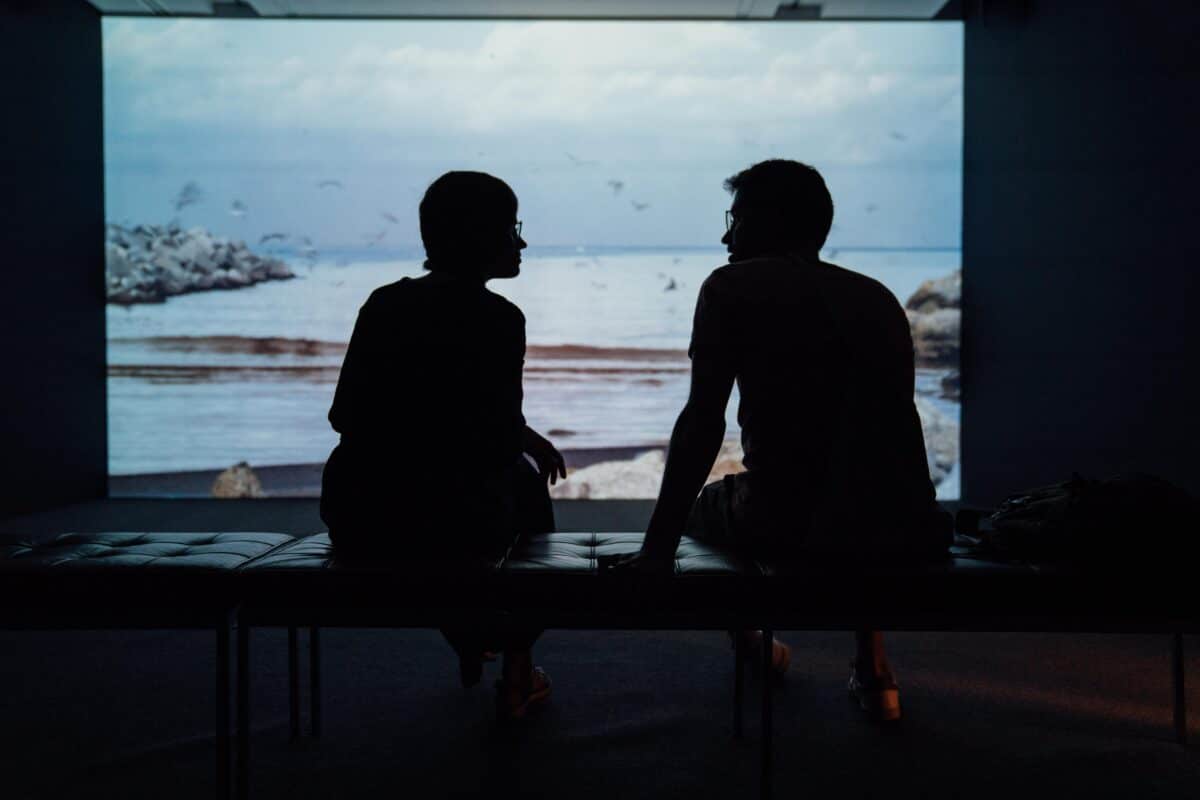 The silhouette of two people sitting and talking together, showing the importance of trying to learn from those around you