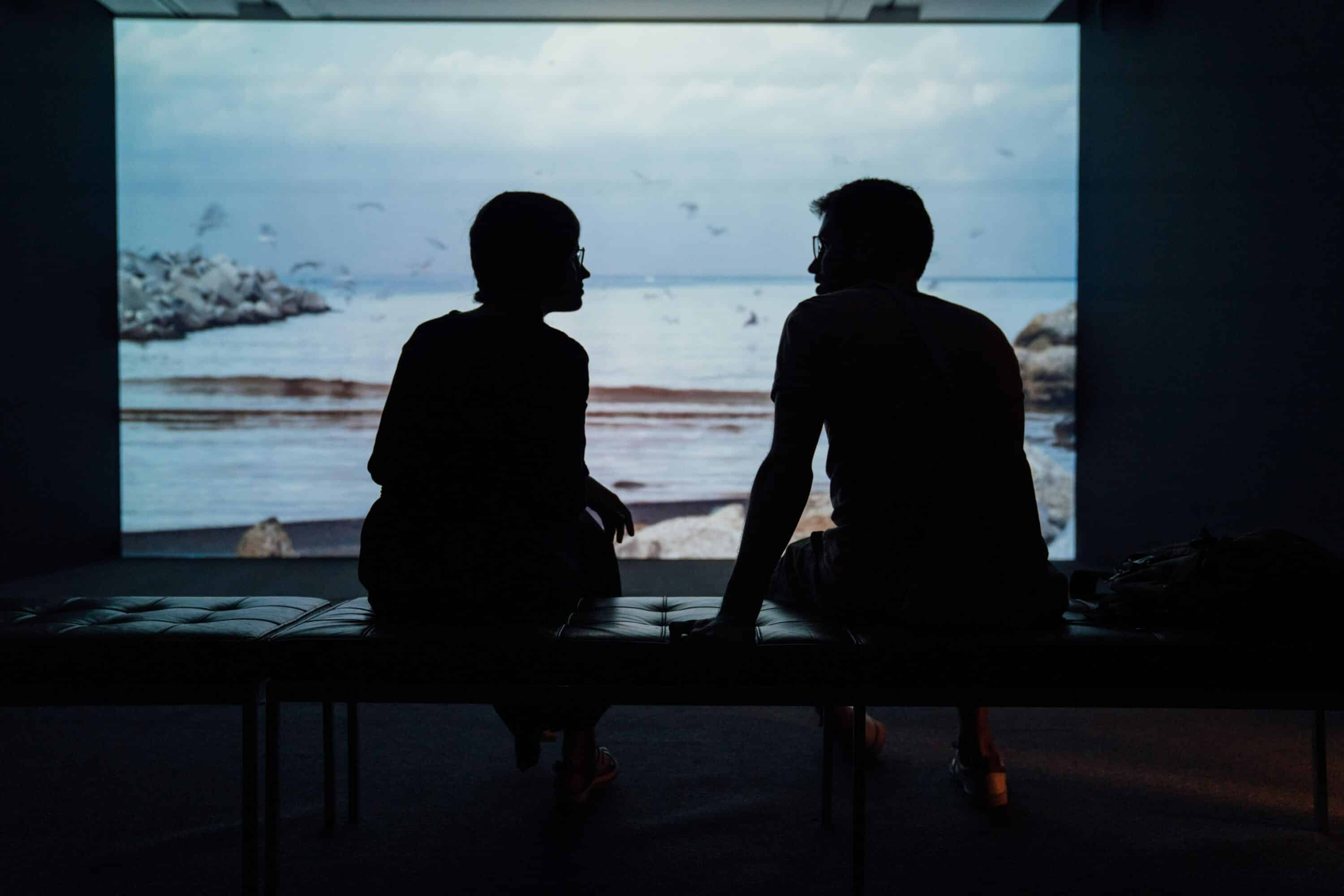 The silhouette of two people sitting and talking together, showing the importance of trying to learn from those around you